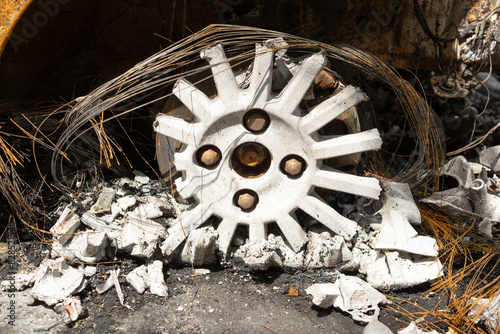 burnt out car wheel with debris and metal wire