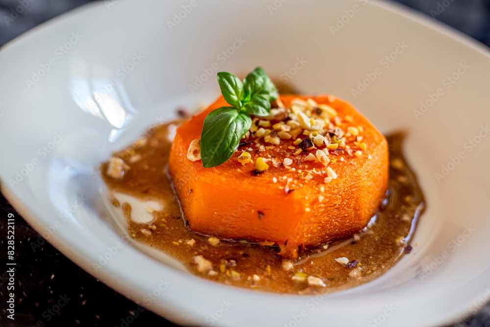 Sliced roasted pumpkin with honey and walnuts on a white plate Sliced roasted pumpkin with honey and walnuts on a white plate
