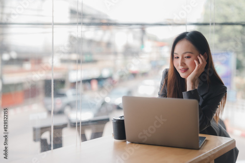 Wallpaper Mural business woman wearing suit drinking coffee using laptop in cafe. Torontodigital.ca