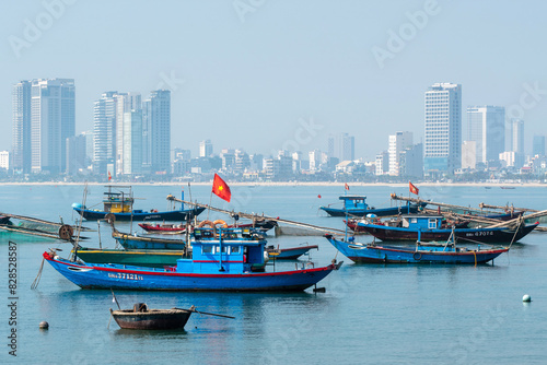 View of traditional Vietnamese fishing boats on the background of the city on sunny day. Da Nang, Vietnam. © Kirill