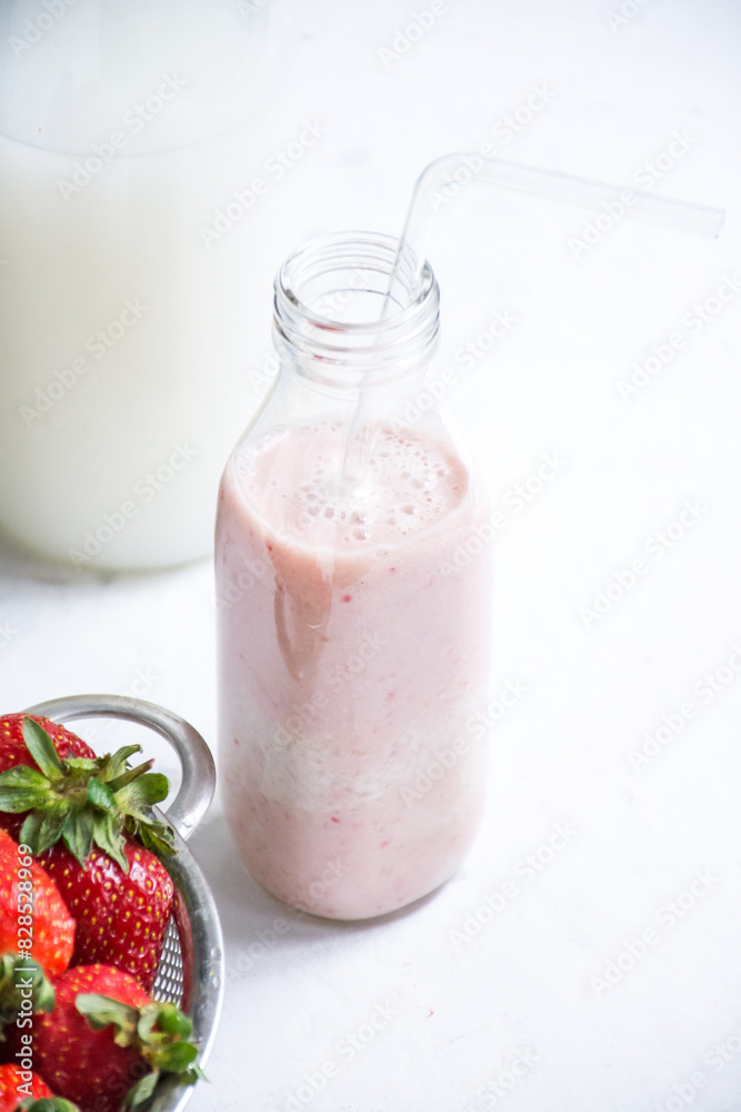 Small jar and metal colander filled with fresh strawberries Small jar and metal colander filled with fresh strawberries