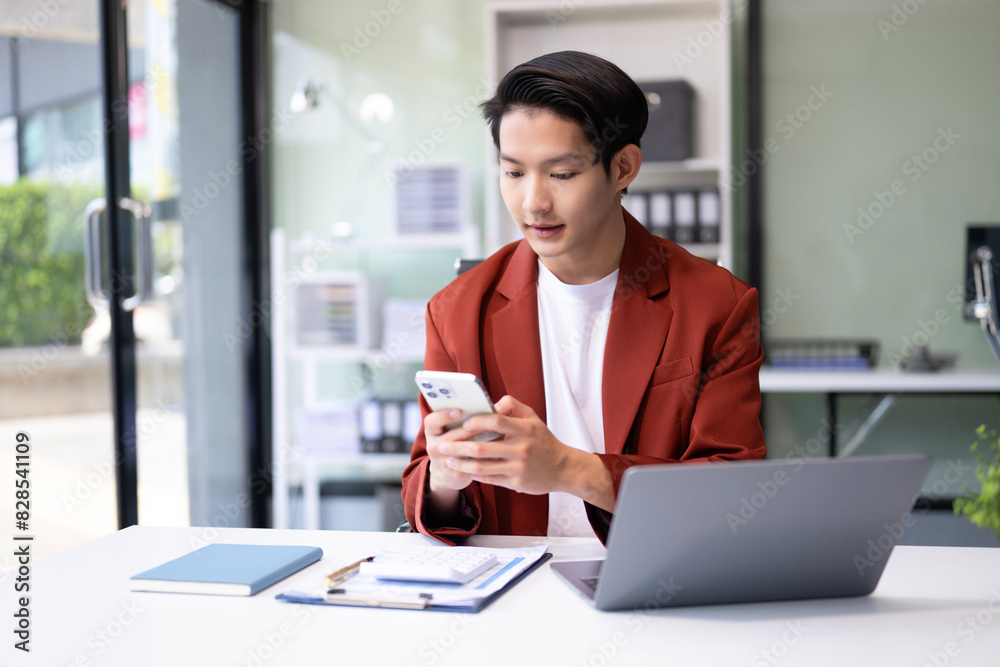 Confident Asian man with a smile standing holding notepad and tablet at the modern office. Confident Asian man with a smile standing holding notepad and tablet at the modern office.