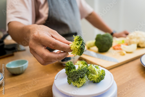 Chef at the kitchen preparing lentils soup with cauliflower and broccoli