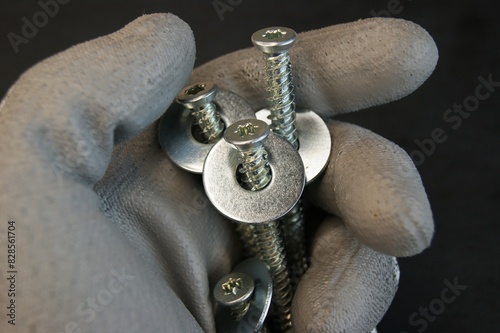 Construction work process. The builder holds large screws.