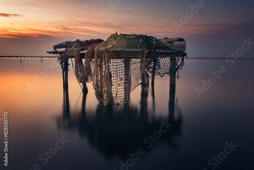 Rustic table with fishing tackle in the Ebro Delta, Tarragona, at dawn over the Mediterranean Sea photo