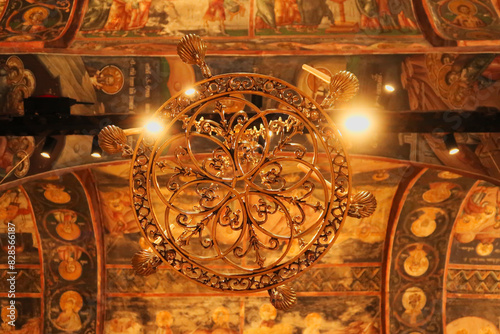 Chandelier inside the Church Complex of the Patriarchate of Pec Monastery, hanging from a ceiling completely covered in colorful paintings, frescos, outside of Peja, Kosovo