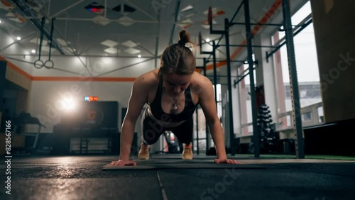 faces In the gym girl trainer does push-ups on the floor directly at the camera
