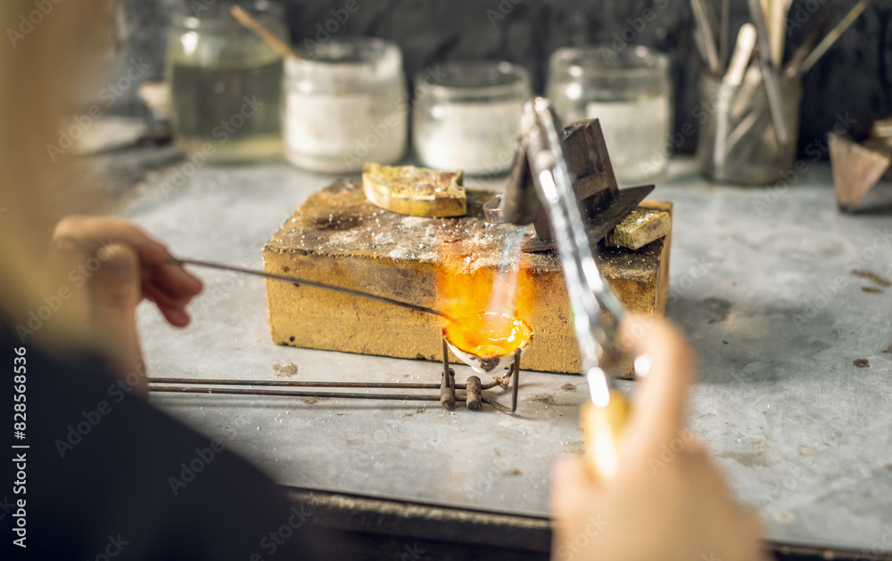 Heating with a flame jet of a metal billet of a silver ring. The work of a jeweler in the workshop Heating with a flame jet of a metal billet of a silver ring. The work of a jeweler in the workshop