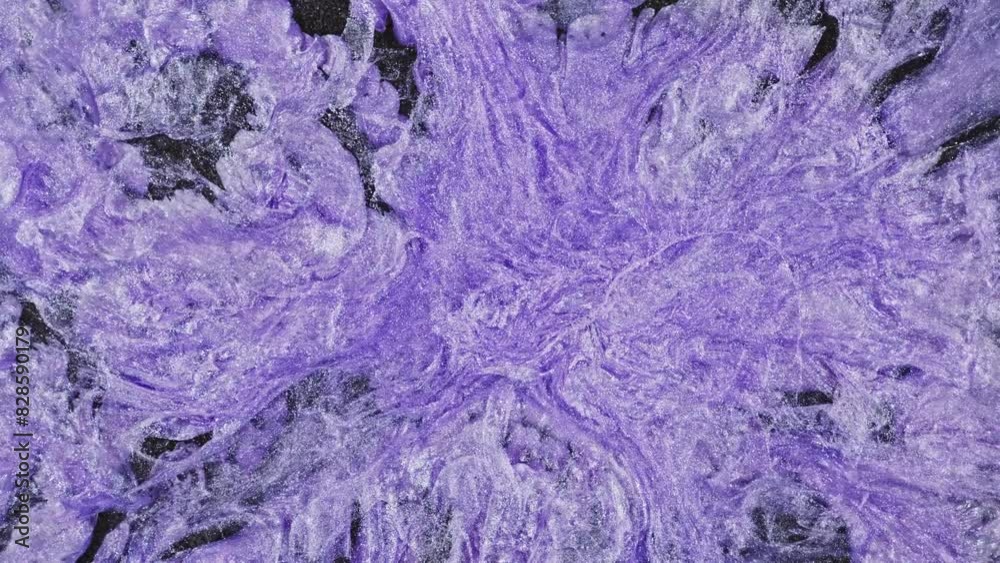 Top view of a purple fluid texture with shinny lilac swirls and veins, painted in the style fluid art acrylic. The macro video on a dark glitter background. Top view of a purple fluid texture with shinny lilac swirls and veins, painted in the style fluid art acrylic. The macro video on a dark glitter background.