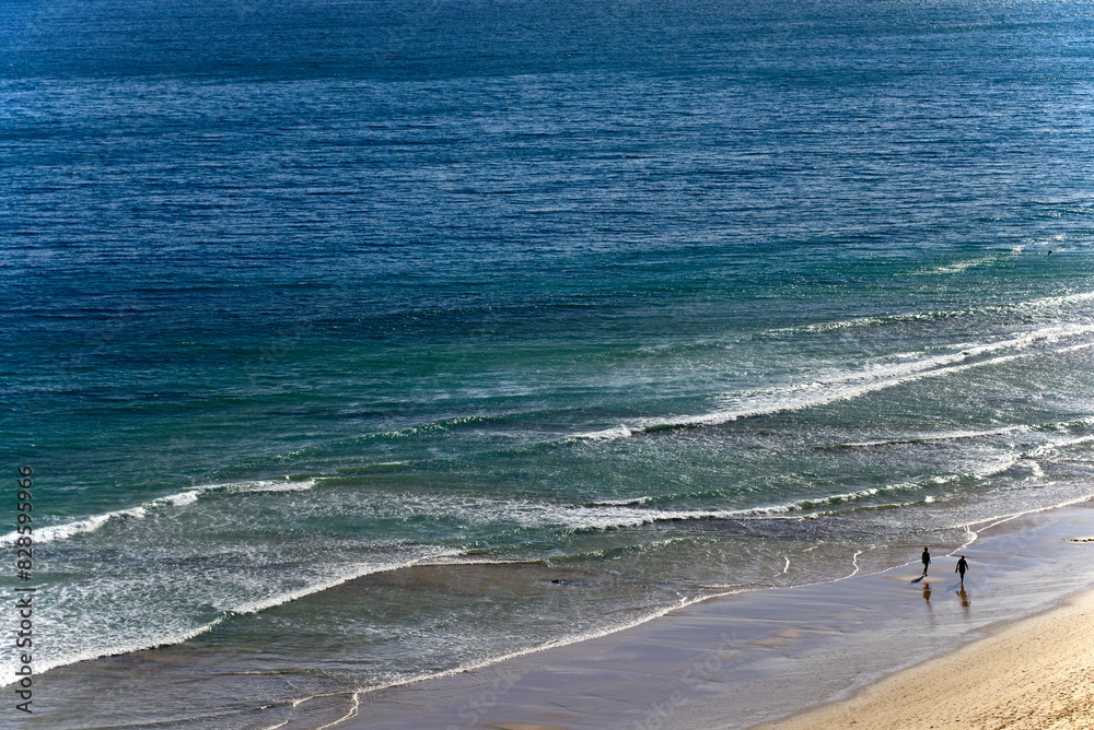 Φωτογραφία Lagos, Faro district, Algarve, Portugal, Europe - two persons walking on calm Po