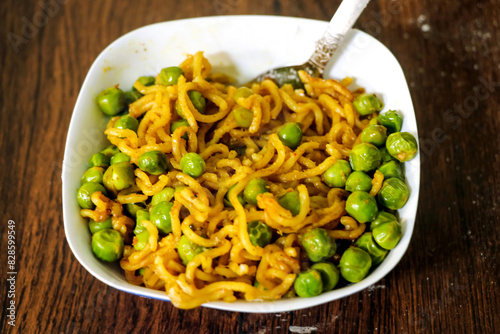 Tableau sur toile Maggie Noodles with Green peas served in a bowl over a rustic wooden background