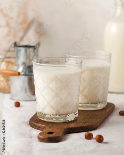 Two glasses of fresh milk served on a rustic wooden board