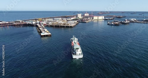A passenger oil industrial vessel approaches the overpass on the oil rocks
