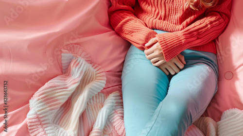 Female person with pink blanket having period cramps