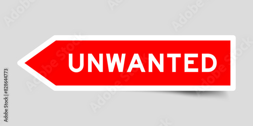 Red color arrow shape sticker label with word unwanted on gray background