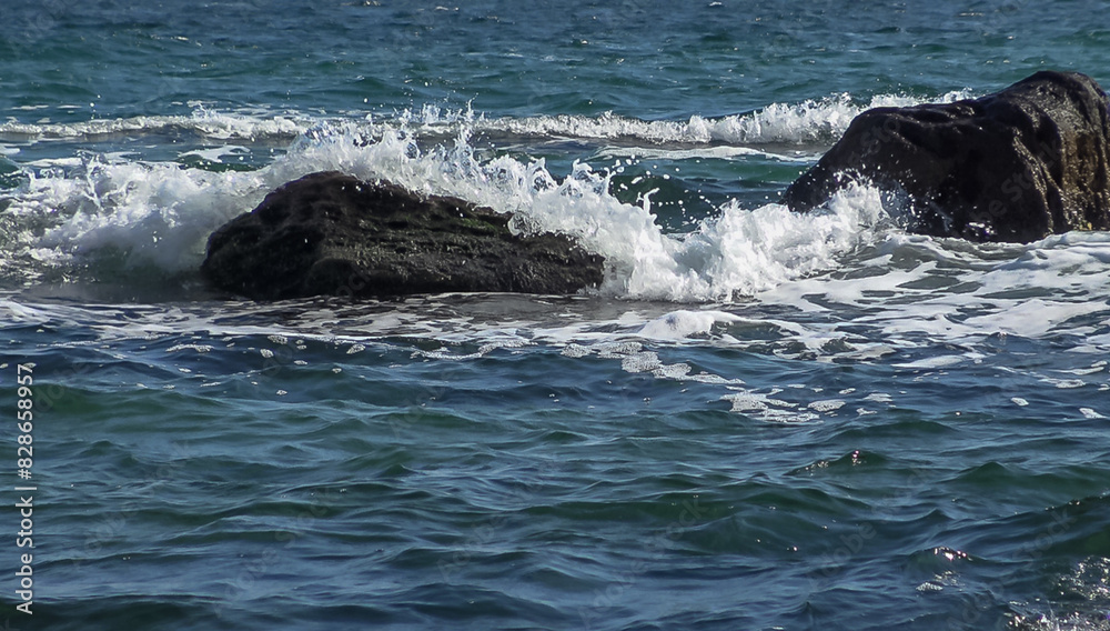 Fototapeta premium White foam and big waves crash on yellow rocks in the Black Sea during a storm
