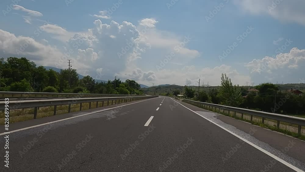 Road view on a summer day. Highways and landscape, palm trees and mountains, roadside and white road line markings. Road view on a summer day. Highways and landscape, palm trees and mountains, roadside and white road line markings.