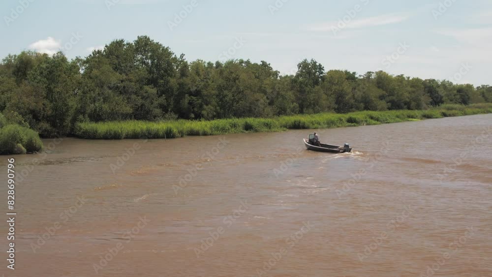 Aerial: Drone Panning Shot Of People Exploring River In Motorboat Moving Amidst Green Landscapes On Sunny Day - Bayou Vista, Texas Aerial: Drone Panning Shot Of People Exploring River In Motorboat Moving Amidst Green Landscapes On Sunny Day - Bayou Vista, Texas