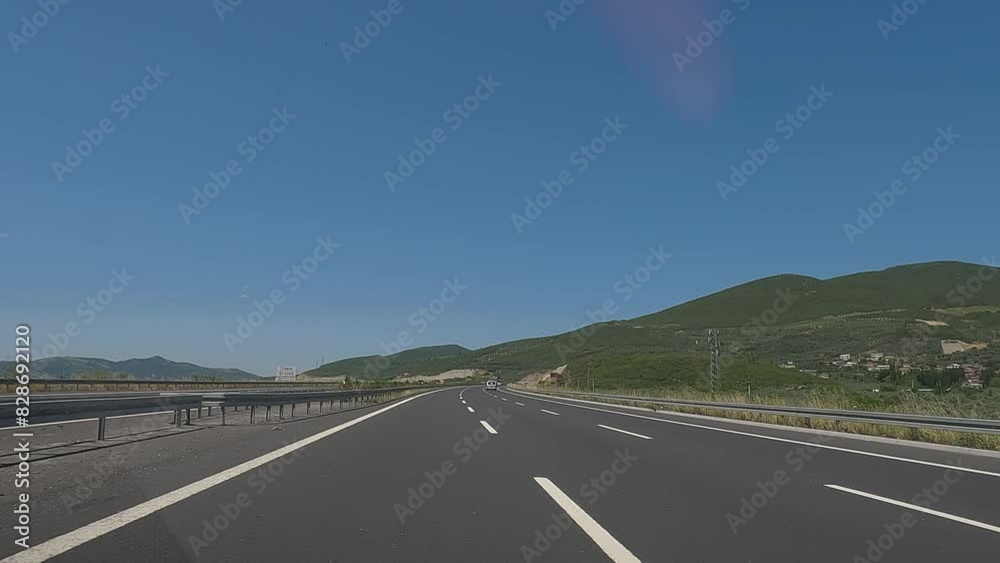 Road view on a summer day. Highways and landscape, palm trees and mountains, roadside and white road line markings. Road view on a summer day. Highways and landscape, palm trees and mountains, roadside and white road line markings.