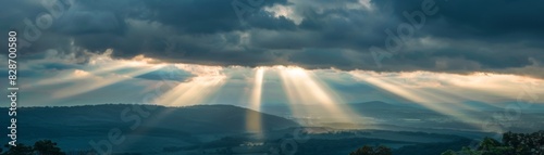 Scenic sunrise over mountains with sun rays breaking through clouds  creating a dramatic and serene natural landscape view.