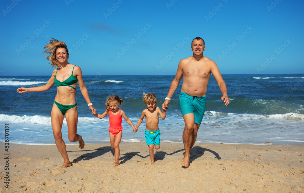 Parents and kids hold hands on beach run with carefree smile Parents and kids hold hands on beach run with carefree smile