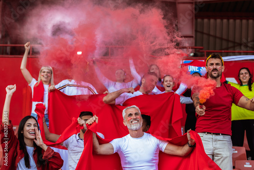 Sport fans lit torches in the stadium at the game. Red colors, flags, stadium. photo