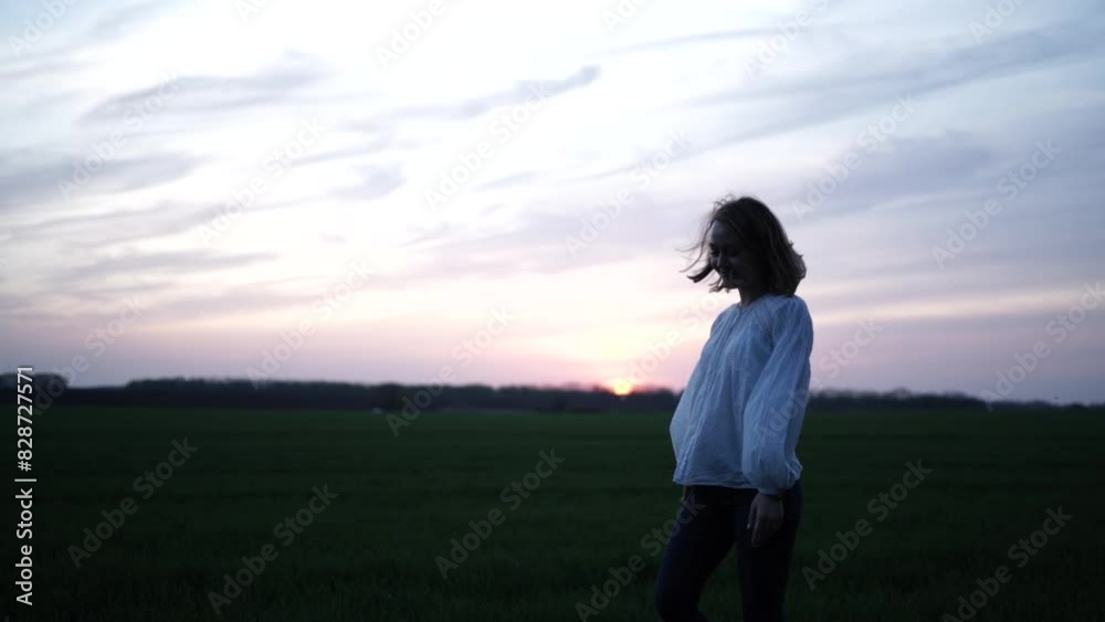 Beautiful girl walking on the green field. Girl at sunset on the wheat field Beautiful girl walking on the green field. Girl at sunset on the wheat field