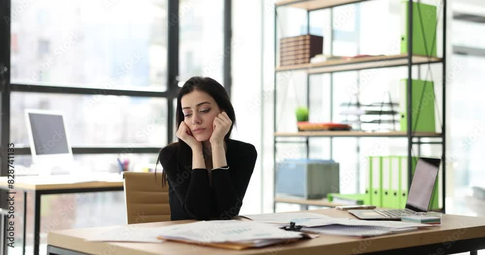 Business woman in office is serious about work stressed and worried about not completing tasks on time. Work fatigue and burnout Business woman in office is serious about work stressed and worried about not completing tasks on time. Work fatigue and burnout