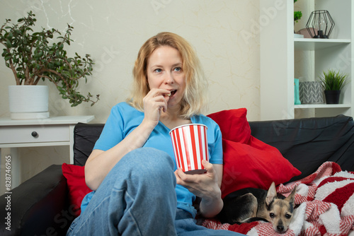 Woman with dog watching tv pet show at home, in the living room, cozy and comfortable, streaming a movie