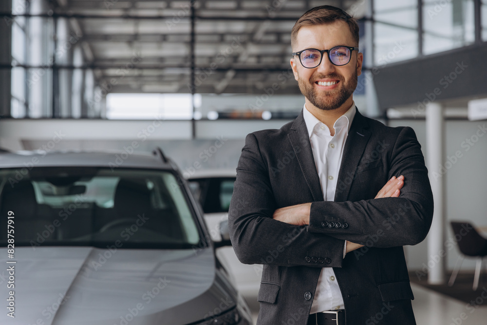 Portrait of Modern car seller standing in car salon with arms crossed with copy space Portrait of Modern car seller standing in car salon with arms crossed with copy space