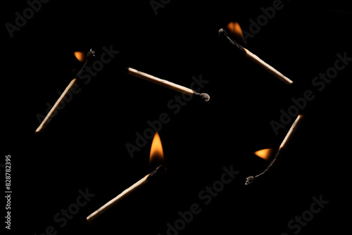 Lit falling match on a black background.