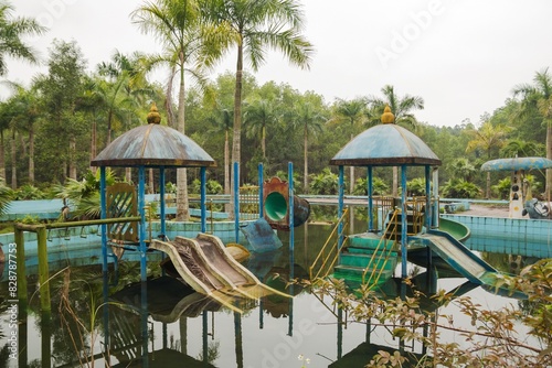 An abandoned playground with faded colors, rusty equipment, and dangerous water leaks. Abandoned Waterpark in Hue, Vietnam.