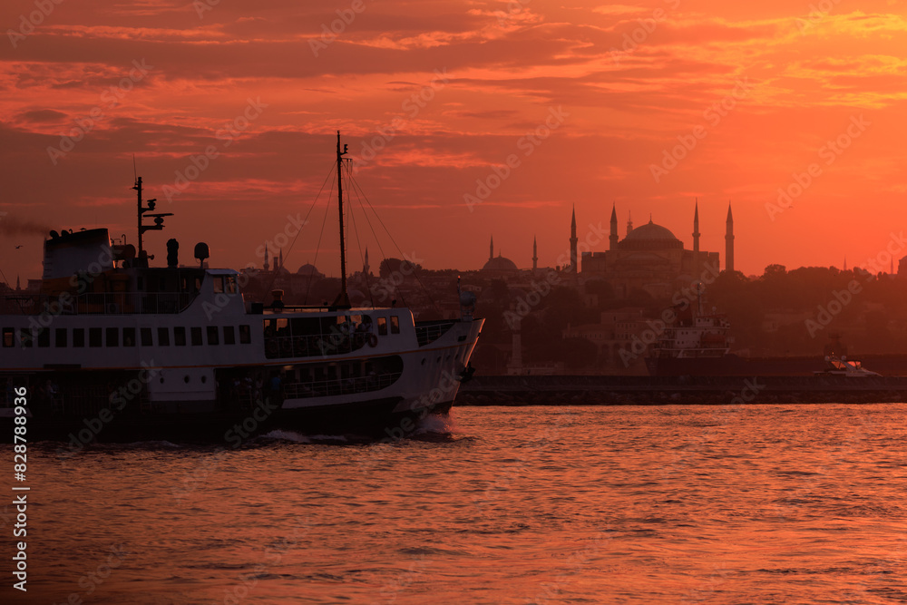 Fototapeta premium Orange sky at sunset in the evening. Silhouette and outlines of the buildings. Evening views of buildings of the city of Istanbul.