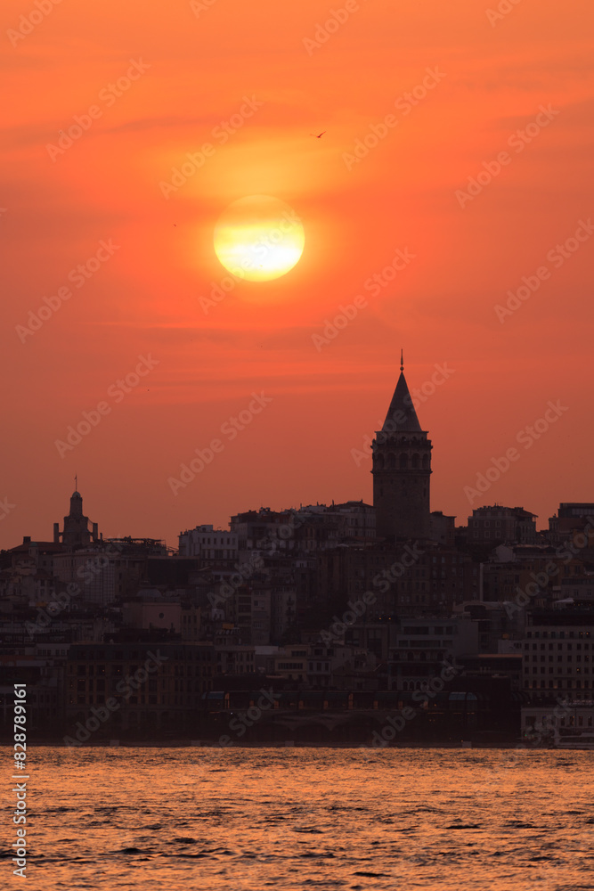 Obraz premium Orange sky at sunset in the evening. Silhouette and outlines of the buildings. Evening views of buildings of the city of Istanbul.