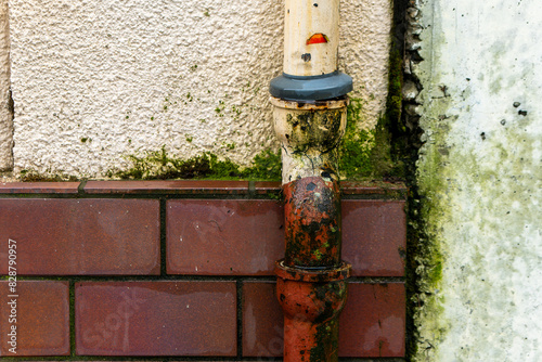 old dilapidated rain pipe in front of a house wall