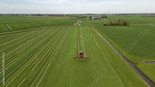 Harvesting Season: Aerial Shot of Tractor Shaking Grass on Farmland (ID: 828802130)
