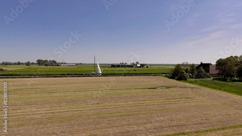Sailing Boat Cruising through the Frisian Countryside in the Netherlands (ID: 828805100)