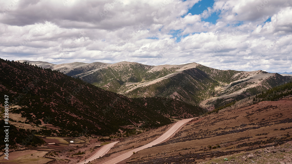 high altitude mountains with sparse plants and red soil in eastern tibet