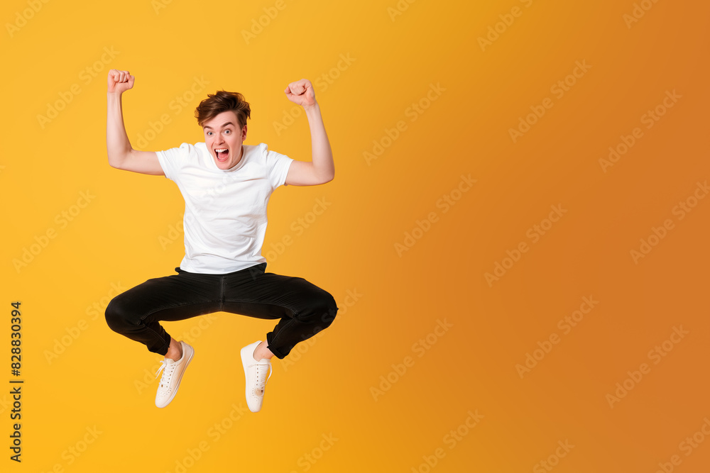 Funny young man jumping, on yellow background