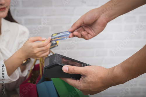 Customer woman using credit card for payment. Salesman holding a credit card swipe machine or electronic data capture along with accepting credit cards from customers.
