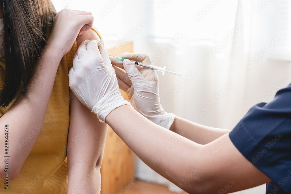 People getting a vaccination to prevent pandemic concept. girl in medical face mask  receiving a dose of immunization coronavirus vaccine from a nurse at the medical center hospital