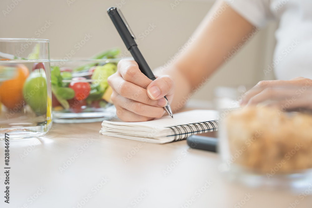 © Pormezz - person take note of weight and counting of calories to eat in each day © Pormezz - person take note of weight and counting of calories to eat in each day