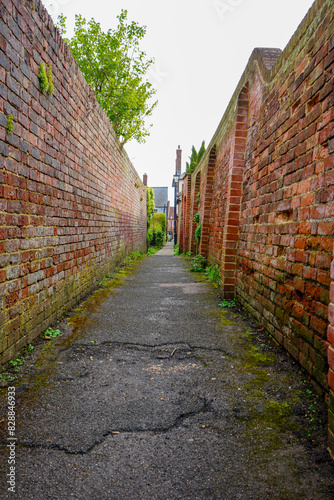 View down an alleyway in with red brick walls