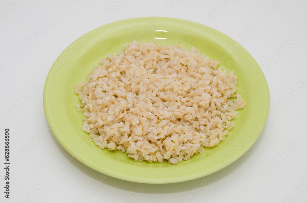 Plate of cooked brown rice on a white background Plate of cooked brown rice on a white background
