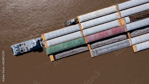 A towboat, known as a pusher, pushes barges full of cargo up the Mississippi River near downtown Baton Rouge, Louisiana, USA.