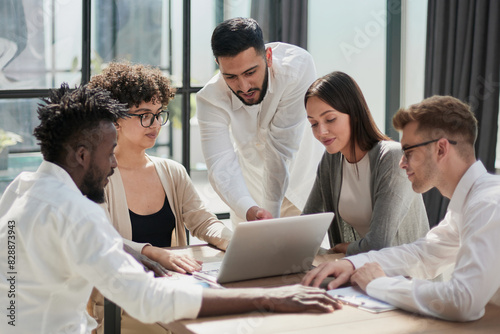 Employees working at computer together, discussing content