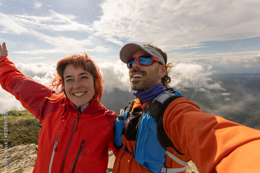 A man and a woman are smiling and posing for a picture on a mountain