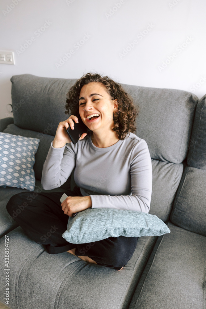 Joyful woman chatting on phone while relaxing on couch Joyful woman chatting on phone while relaxing on couch