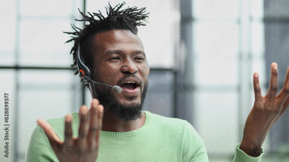 Naklejka premium Smiling friendly handsome young male call centre operator.
