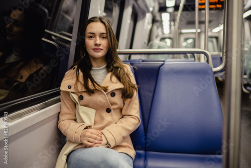 Young woman sitting on public transport, grainy urban scene. 
